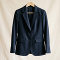 AI-generated illustration of a women's navy blue blazer on an off-white background